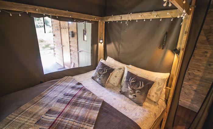 King size four poster bed with fairy lights and a view.